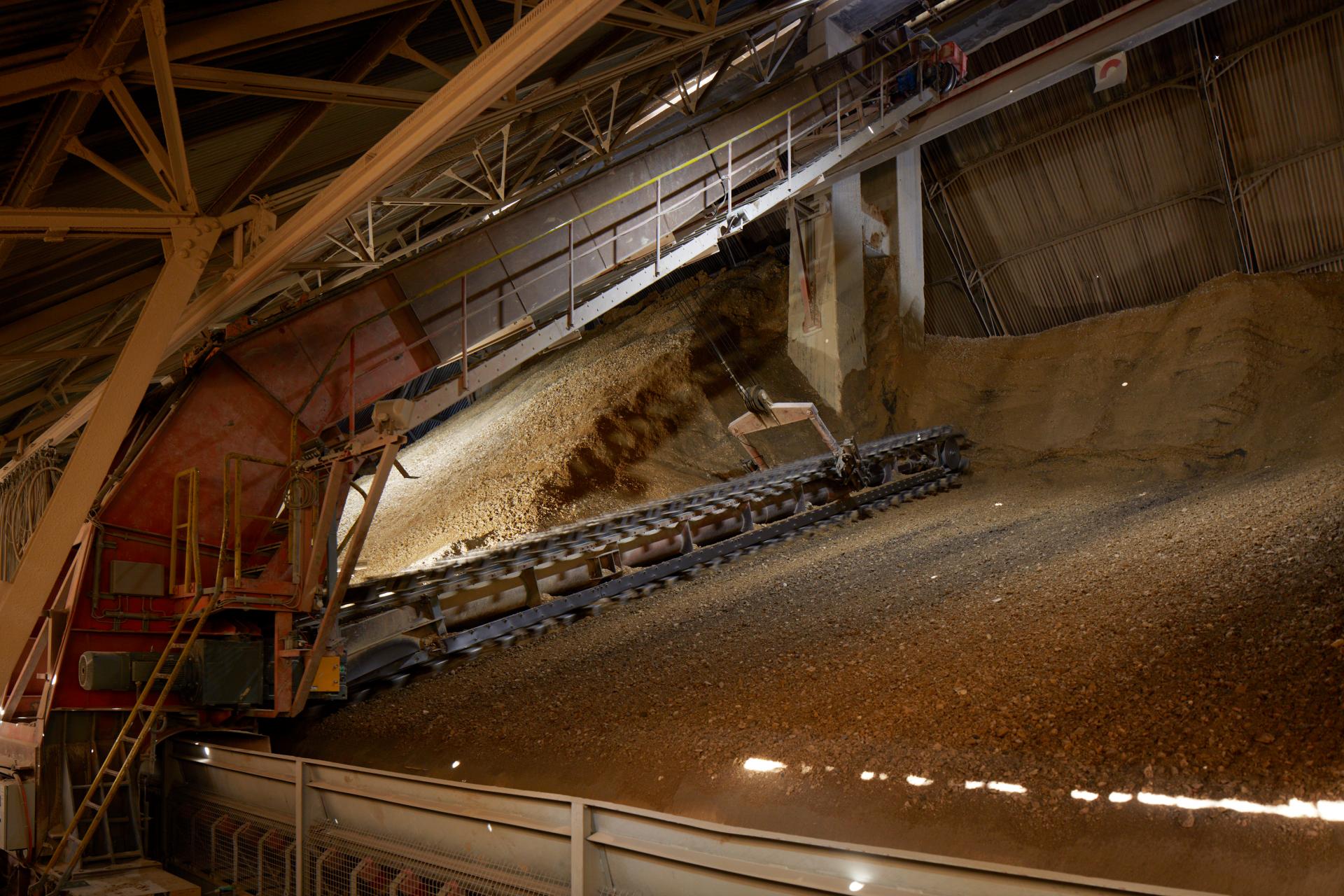 Steinbruchmaterial fällt in eine Rinne und wird abtransportiert.